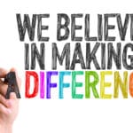 Hand with marker writing We Believe in Making a Difference